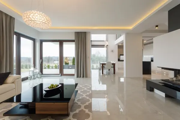 Modern ve düzenli bir oturma odası, açık plan mutfak ve yemek alanı.
