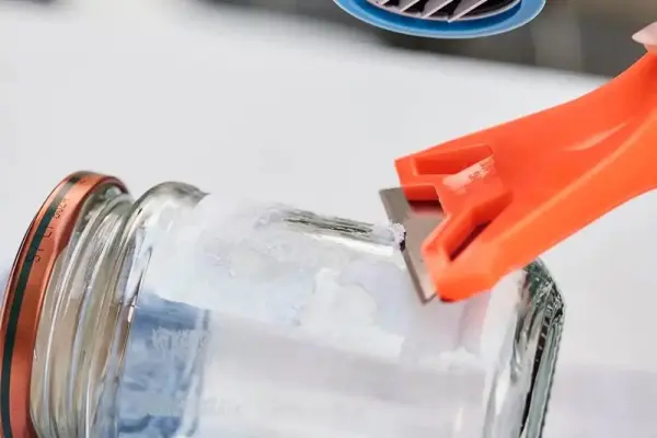 Bir kavanoza bulaşık makinesi deterjanı dökülüyor.