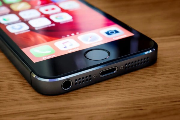Ahşap üzerinde ekranı açık siyah akıllı telefon.
