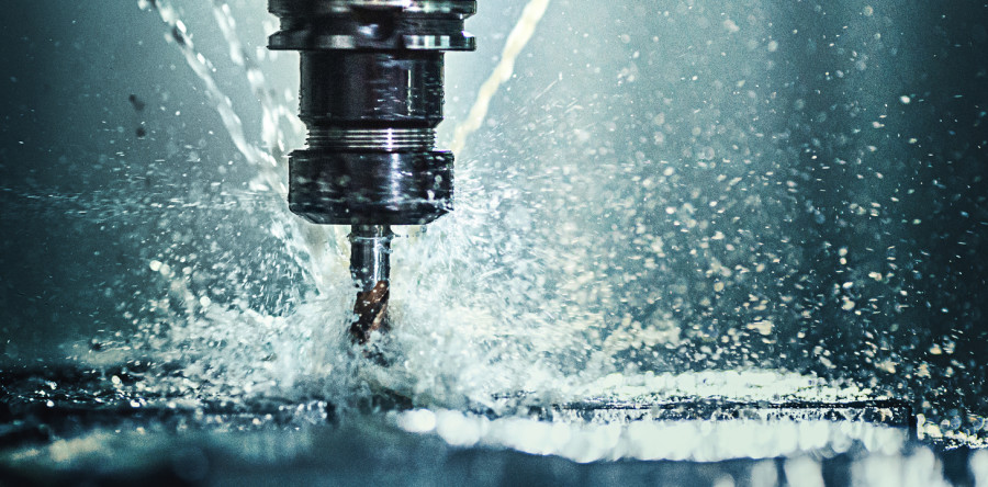Metal işleme sırasında talaşların uçuştuğu CNC makinesi ucu.