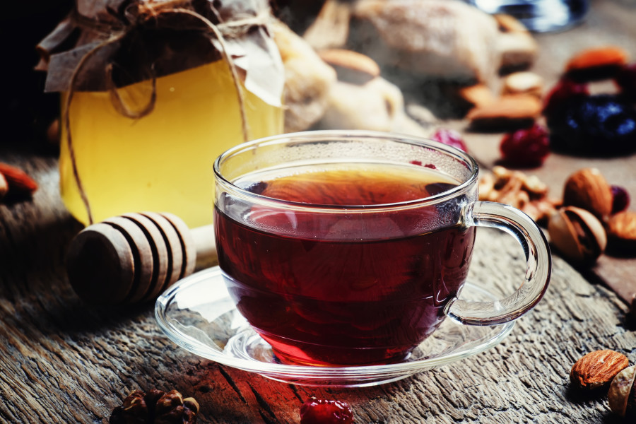 Bir fincan çay, bal kavanozu ve kuru yemişler.