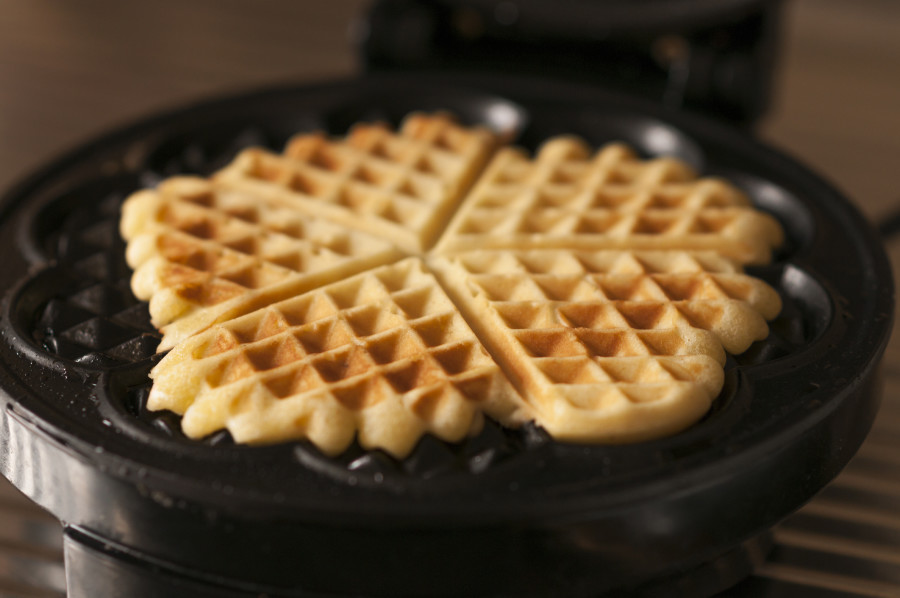 Vaffle makinesinde dört adet altın rengi vaffle.