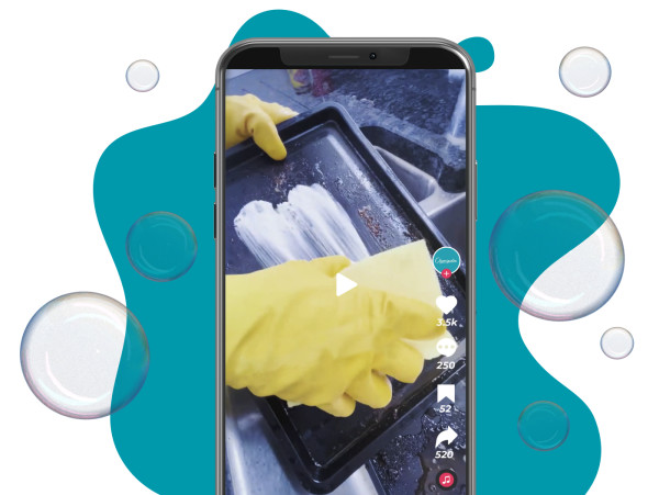 Sarı eldivenli bir kişinin ocak temizliği yaptığı bir video gösteren akıllı telefon ekranı.