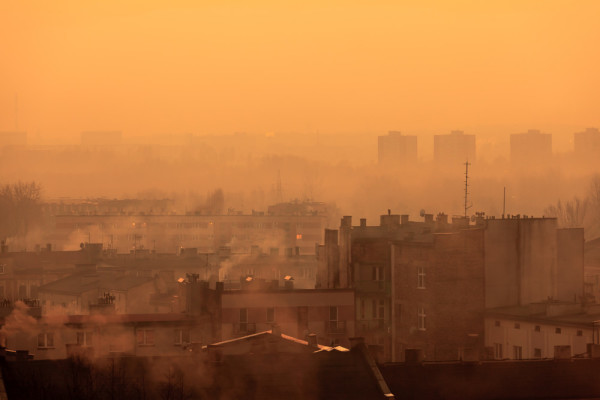 Sisli ve dumanlı bir şehir silüeti.