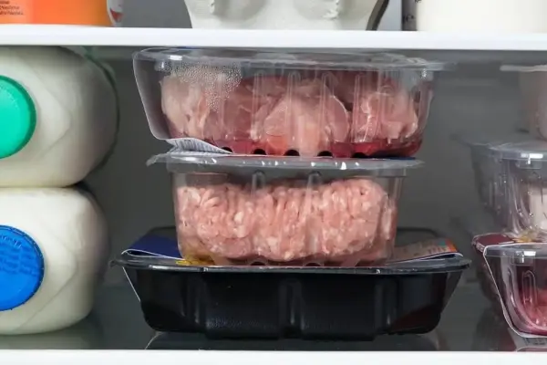 Buzdolabı içinde üst üste konmuş çiğ et paketleri.