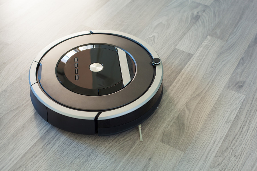 Parke zemin üzerinde siyah renkli robot süpürge.