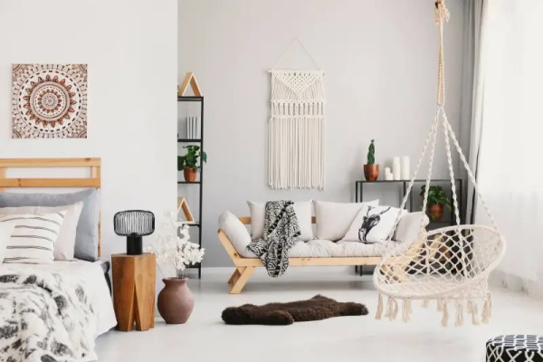 Düzgün düzenlenmiş ve dekore edilmiş minimalist oturma odası, asma sandalye ve bitkiler içerir.