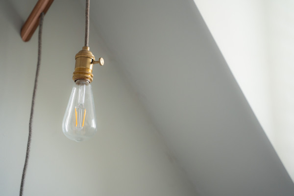 Duvara monte edilmiş, açık halde bir Edison ampulü.