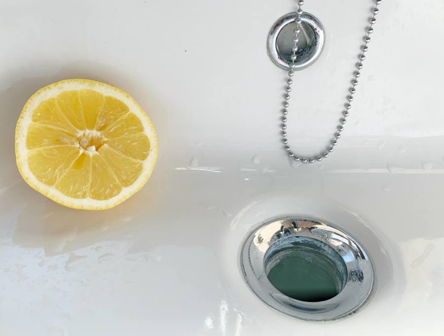 Lavabo içerisinde bir dilim limon ve su gideri.
